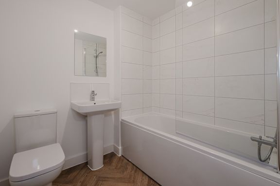 A white bathroom with a toilet, sink, and bathtub.