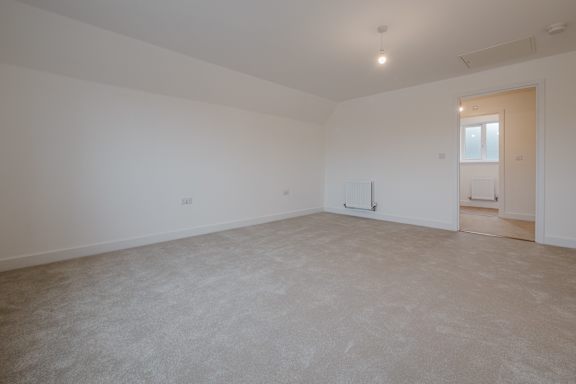 Empty room with white walls and carpeted floor.