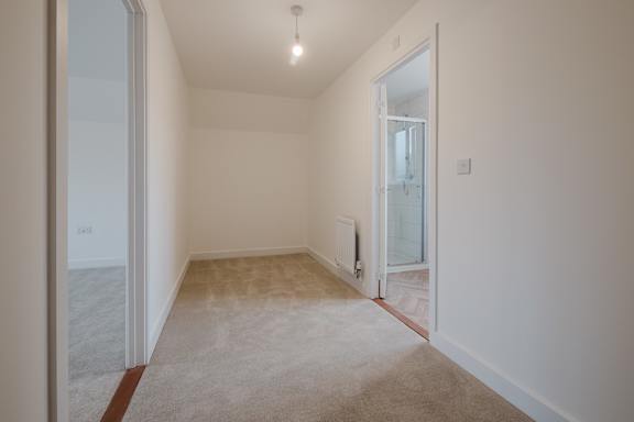 A room with a carpeted floor and a door leading to another room.