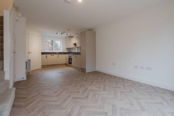 A room with a herringbone patterned floor and a window.