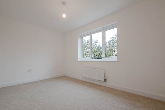 A room with a window and a radiator on the wall.
