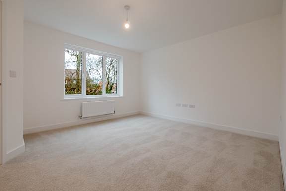 A room with a window and a radiator on the wall.