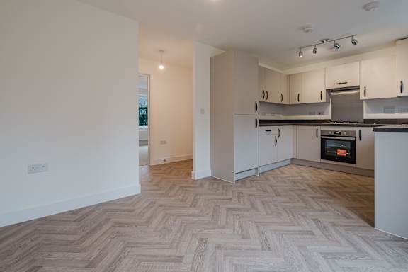 A spacious kitchen with a herringbone patterned floor.