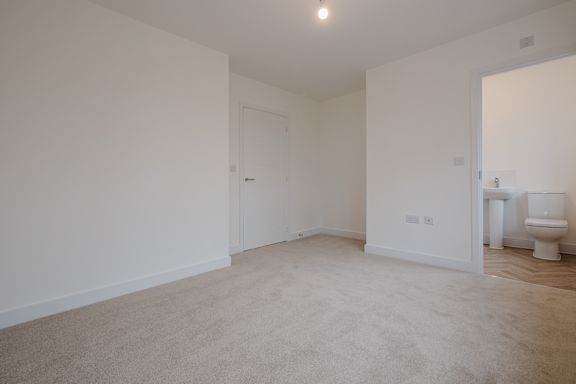 A white room with a toilet in the corner.