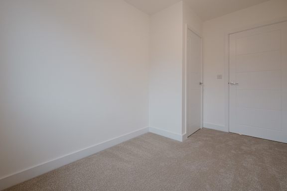 A room with white walls and carpeted floor.