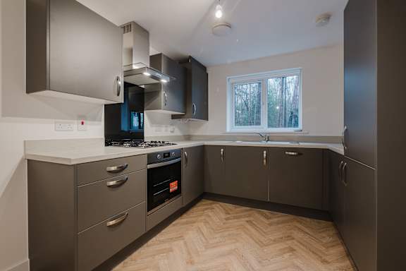 A modern kitchen with a wood floor and stainless steel appliances.