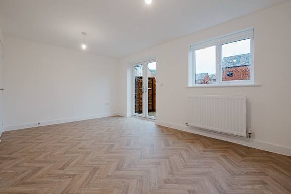 A room with a herringbone patterned floor and a window.