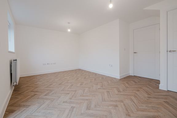 A room with a wooden floor and white walls.