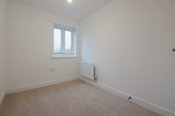A room with a window and a radiator on the wall.