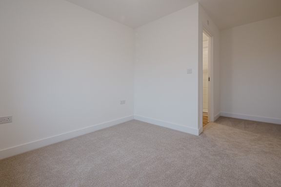 A room with white walls and carpeted floor.