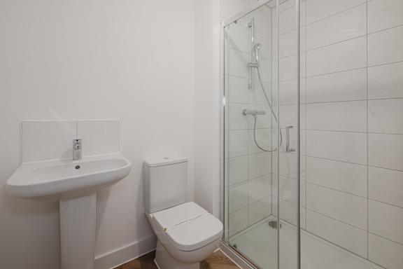 A white toilet sits next to a sink in a small bathroom.