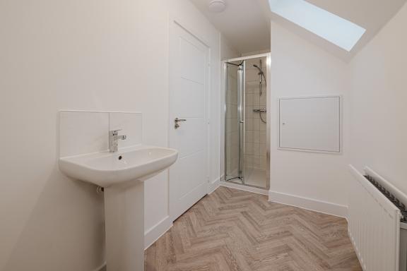 A bathroom with a sink and a shower.