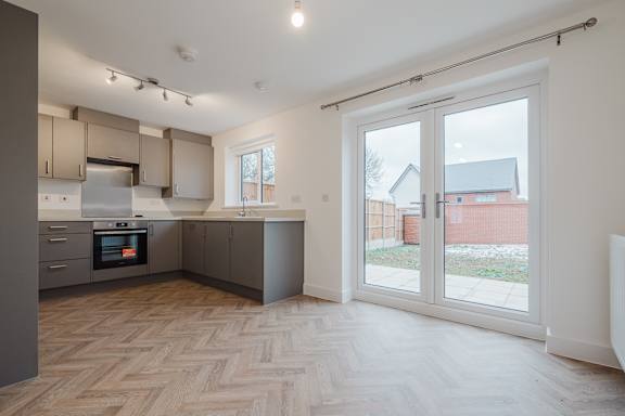 A kitchen with a wooden floor and a white ceiling.
