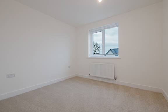 A room with a window and a radiator on the floor.