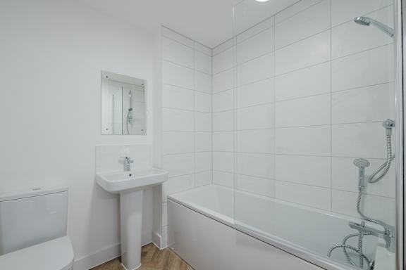 A white bathroom with a sink, toilet, and bathtub.