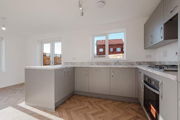 A kitchen with a white countertop and grey cabinets.