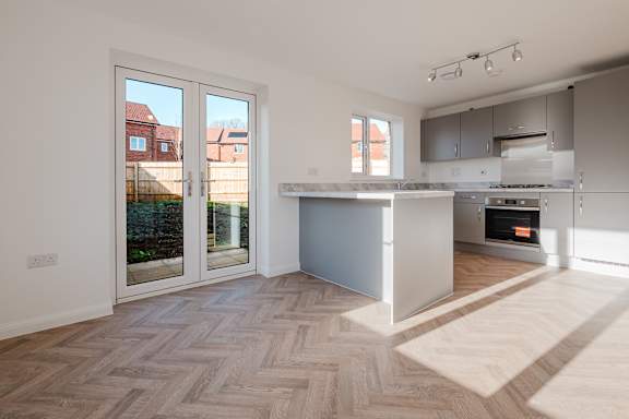 A modern kitchen with a wooden floor and a large island.
