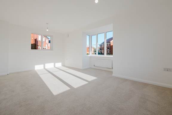 A white room with a large window and a radiator on the wall.