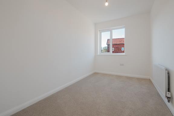 A room with a window and a radiator on the wall.