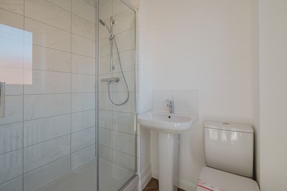 A white sink sits under a mirror in a bathroom.