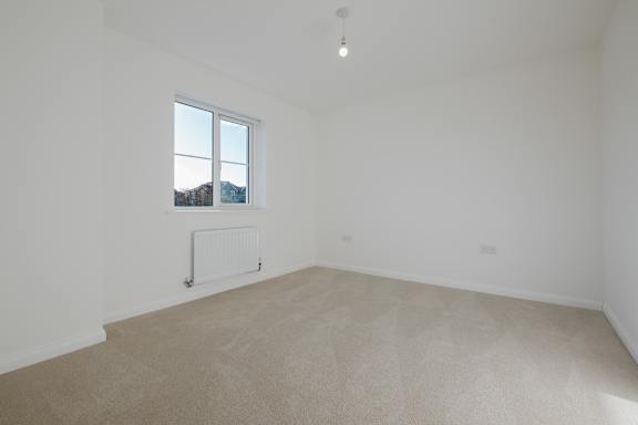 A room with a window and a radiator on the wall.