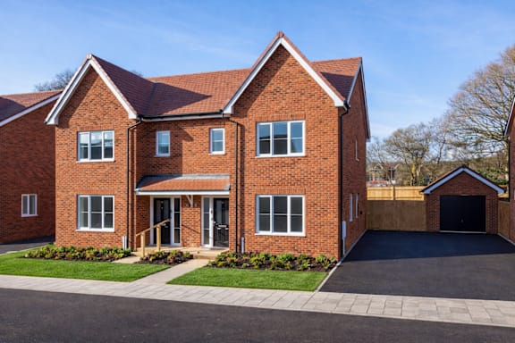A red brick house with a black garage door.