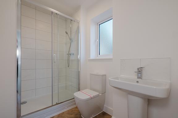 A white toilet with a red stripe is next to a white sink in a bathroom.