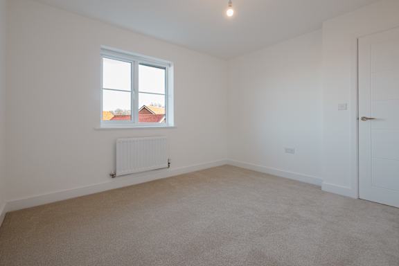 A room with a window and a radiator on the wall.