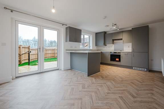 A modern kitchen with a wooden floor and a large island.