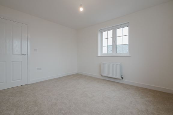 A room with a window and a radiator on the wall.