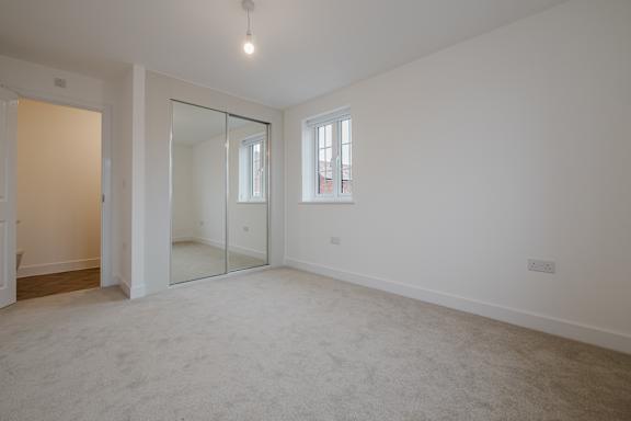 A large empty room with a glass door and a window.
