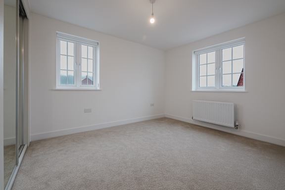 A room with a carpeted floor and a window.