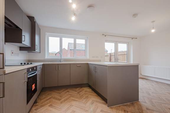 A kitchen with a stove top oven and a window.