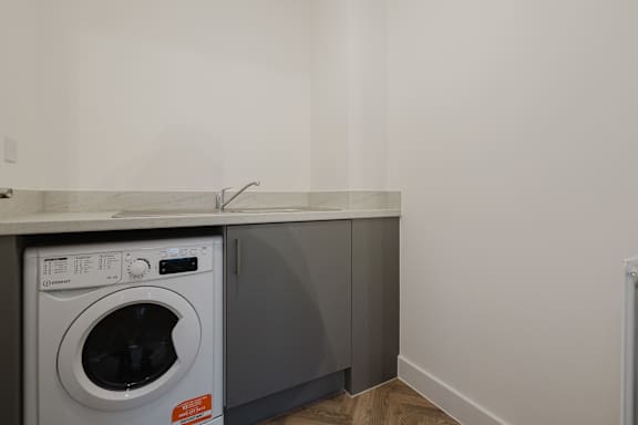 A washing machine is sitting in a laundry room.