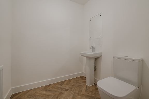 A white toilet sits next to a sink in a small bathroom.