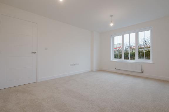 A white room with a window and a radiator.