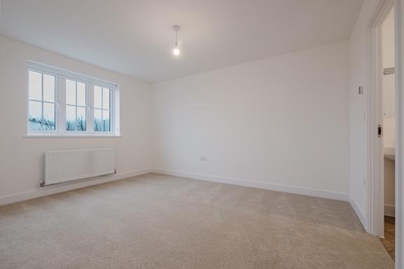 A white room with a window and a radiator.