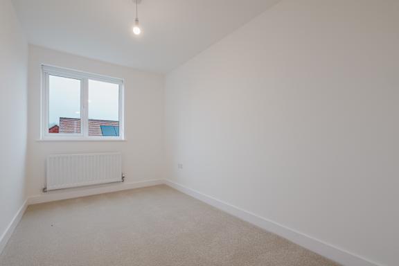 A room with a window and a radiator on the wall.