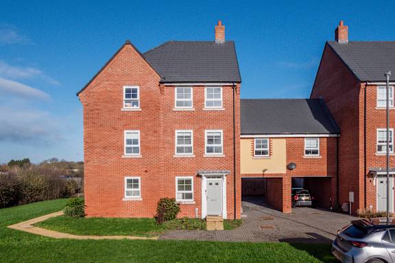 A red brick house with a white door and windows.