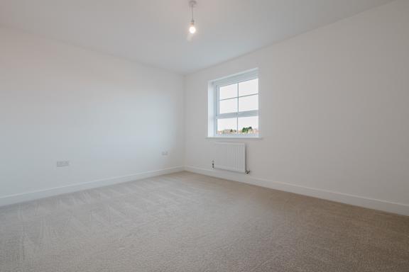 A room with a window and a radiator on the wall.