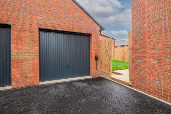 A red brick building with a grey garage door.