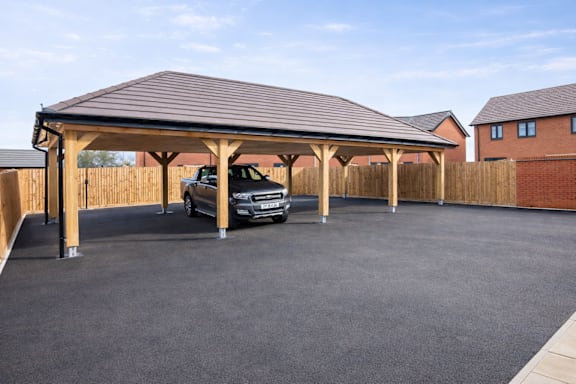 A car is parked in a covered parking area.
