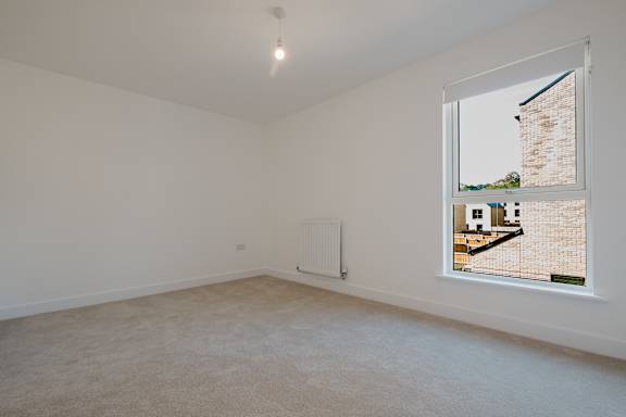 A room with a window showing a view of a building outside.