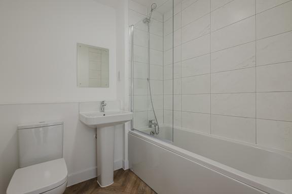 A white toilet sits next to a sink in a bathroom.