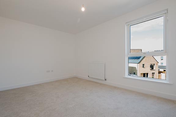 A room with a window showing a view of a building outside.
