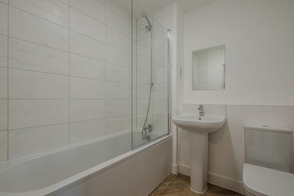A white bathroom with a sink, toilet, and bathtub.