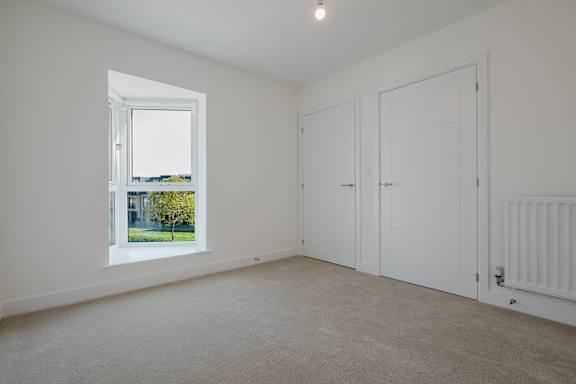 A room with a window, two doors, and a radiator.