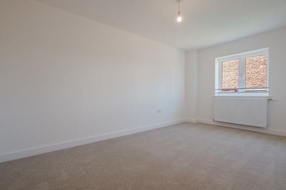 A room with a window and a radiator on the wall.