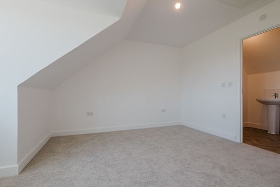 A room with a carpeted floor and a white wall.
