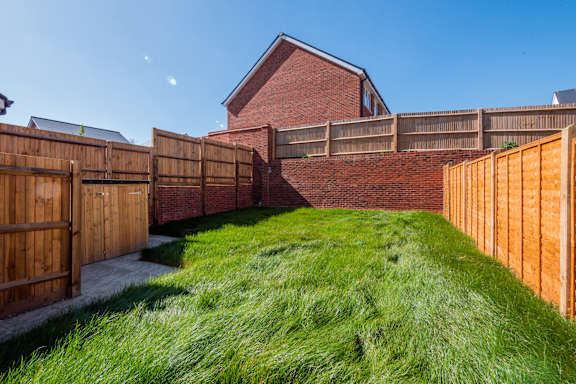 A house with a red brick wall and a wooden fence.
